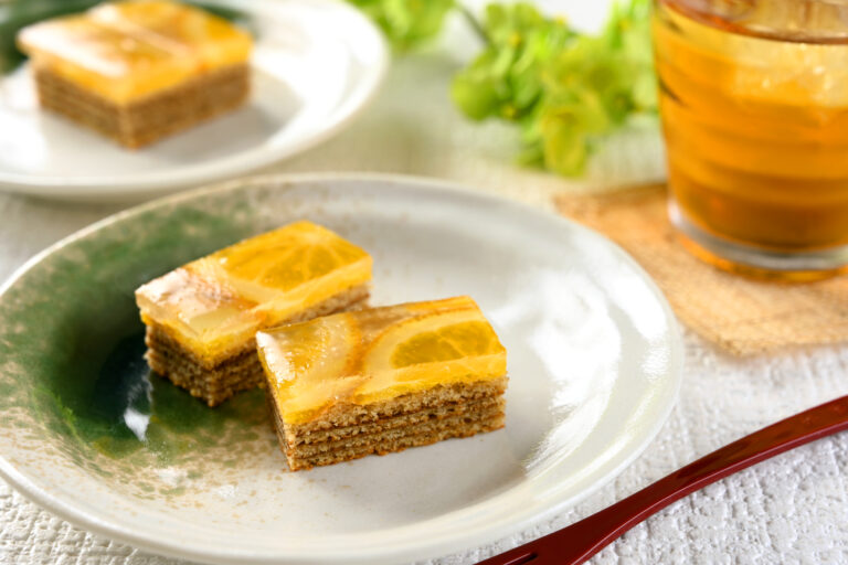 加賀棒茶のバウムクーヘンの上に、オレンジのスライスが入ったわらび餅が。和の趣と洋の爽やかさが魅力の新商品登場。